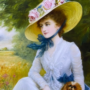 May include: A woman in a white dress and a large straw hat with pink roses sits in a field with a small dog. The woman is holding a bouquet of white flowers.