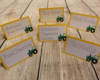 Puede incluir: Seis tarjetas de mesa con temática de granja, con bordes amarillos e ilustraciones de tractores verdes. Las tarjetas muestran texto como "Matthew's Fruit Patch", "Hay Bales" y "Fuel Station".