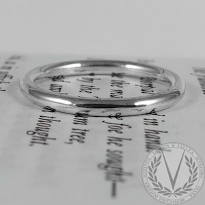 May include: A simple silver band ring, shown on a white background.