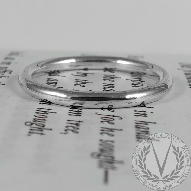 May include: A simple silver band ring, shown on a white background.