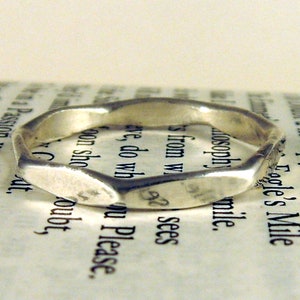 May include: A silver ring with a textured, hammered finish. The ring is thick and has a rounded shape.