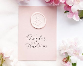 Blush pink recycled wedding place names with calligraphy