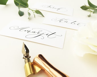 Flat white wedding place names with flourished modern calligraphy in black ink / place cards / personalised name cards for weddings