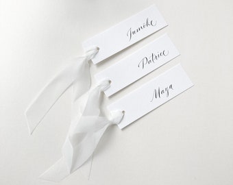 Slimline white wedding place names with black calligraphy and optional off-white silk ribbon