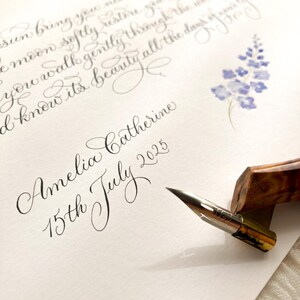 May include: A handwritten calligraphy artwork with the name "Amelia Catherine" and the date "15th July 2025." The script is accompanied by a watercolor floral design and a calligraphy pen.
