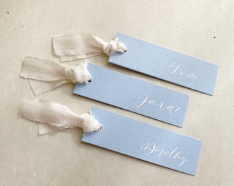 Powder blue slimline wedding place names with pale ivory silk ribbon and calligraphy