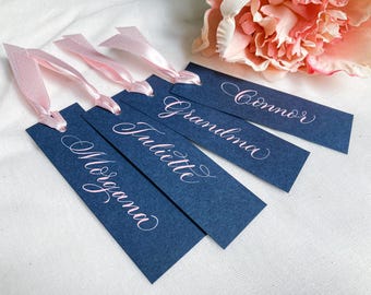 Pretty navy blue wedding place name tags with pink calligraphy and satin ribbon