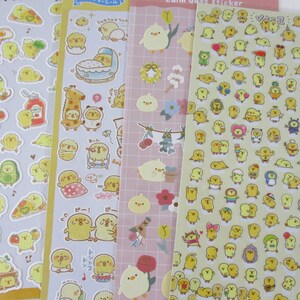 May include: Four sheets of stickers featuring yellow chicks in various poses and settings. The stickers are on a white background with a yellow border. The stickers include a chick in a crib, a chick with a pizza, a chick with a drum, and a chick with a flower.