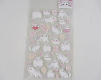 May include: A sheet of clear sticker paper with white cats and pink flowers. The stickers say "Cat" and "Thanks".