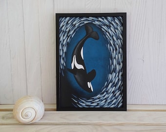 May include: A framed painting of a black and white orca swimming through a school of silver fish on a blue background.