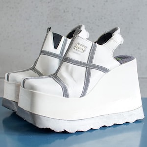 Può includere: Scarpe platform bianche con cinturino grigio e suola testurizzata.