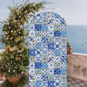 Może przedstawiać: Tło w postaci łuku w niebiesko-białe wzory z kompozycją kwiatową z przodu. Łuk wykonany jest z płytek z różnymi wzorami geometrycznymi. Kompozycja kwiatowa składa się z białych i żółtych kwiatów.