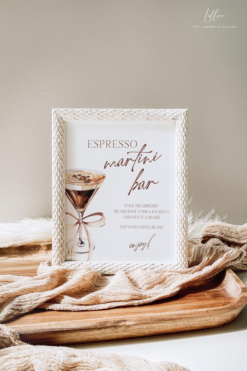 May include: White framed sign with the text "ESPRESSO martini bar" in brown lettering.  The sign also includes a watercolor illustration of a martini glass with coffee beans and a ribbon.  The text below the illustration reads "POUR THE ESPRESSO SPLASH SOME VODKA & KAHLUA AND GIVE IT A SHAKE TOP WITH COFFEE BEANS enjoy!"