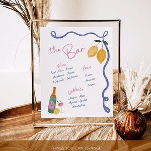 May include: A printable sign for a bar with a blue and white border, lemons, and a glass of wine. The sign lists wine, beer, and cocktail options. The text reads "the Bar", "Wine", "Pinot Noir, France", "Bordeaux, France", "Zinfandel, California", "Cocktails", "Havic Mule", "Aperd Spritz", "Manhattan", "Beer", "Peroni", "Heineken", "Corona". The text below the sign reads "THINGS YOU CAN CHANGE", "edit | add | scale text", "change fonts, text's colors", "change background color", "add your own pictures".