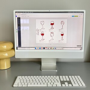 May include: A white computer monitor displaying a digital wine tasting scorecard template. The document features six hand-drawn illustrations of wine glasses, some filled with red liquid, alongside lines for notes and ratings labeled Wine #1 through #6.
