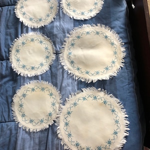 6 white with blue cross stitch doilies
