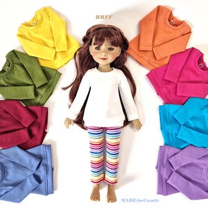 Peut inclure: Une poupée vêtue d'un haut blanc à manches longues et d'un pantalon rayé, entourée de chemises à manches longues de différentes couleurs : jaune, vert, rouge, bleu, orange, rose, turquoise et violet. Le texte "RRFF" et "MABE-la-Creativ" sont visibles.