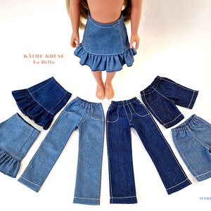 May include: A set of denim clothing for a doll, including a skirt, trousers, and shorts. The clothing is all blue denim with white stitching. The doll is wearing a denim skirt with a frill trim. The text "Käthe Kruse La Bella" is visible in the image.