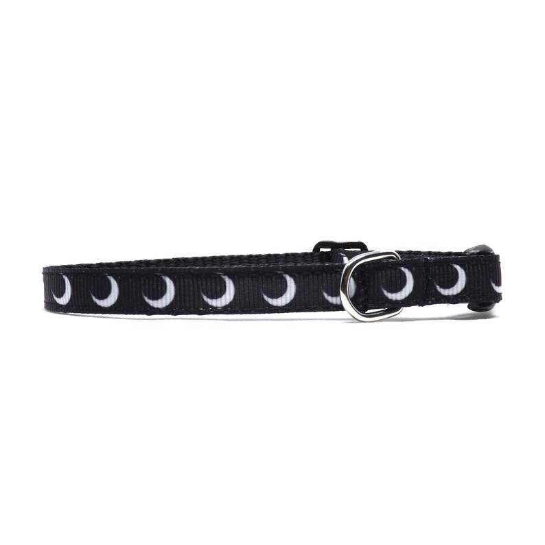 May include: Black cat collar with a white crescent moon pattern.