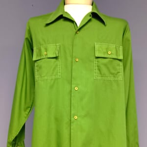 Op de afbeelding: Felgroen shirt met lange mouwen, twee borstzakken en een knoopsluiting. Het shirt wordt op een mannequin getoond. Het heeft een klassieke kraag en manchetten met knopen. De knopen zijn goudkleurig.