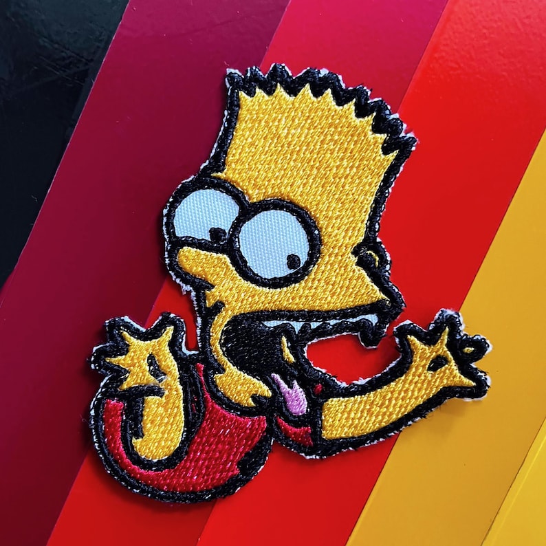 K&ouml;nnte beinhalten: Gestickter Aufn&auml;her mit Bart Simpson mit gelber Haut, stacheligen gelben Haaren und einem roten Hemd. Der Aufn&auml;her zeigt Bart mit &uuml;berraschtem Gesichtsausdruck, offenem Mund und herausgestreckter Zunge. Der Hintergrund hat diagonale Streifen in Rot, Orange und Gelb.