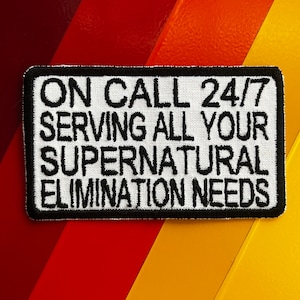 May include: White patch with black embroidered text that reads "On Call 24/7 Serving All Your Supernatural Elimination Needs."