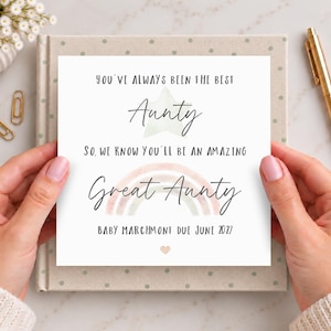 Op de afbeelding: Een vierkante witte kaart met zwarte tekst: You've always been the best Aunty, so we know you'll be an amazing Great Aunty. Baby Marchmont due June 2027. Voorzien van een lichtgroene ster, een regenboog in zachte tinten en een klein hartje.