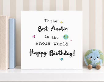 May include: A square white greeting card with black text that reads To the Best Auntie in the Whole World Happy Birthday. The design includes a small colorful illustration of the planet Earth with a smiling face, a yellow star, a blue star, and two pink hearts.