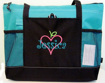 May include: A black tote bag with a turquoise top and mesh side pockets. The bag has a large front pocket with an embroidered pink heart and the name "Jessica" in a cursive font.