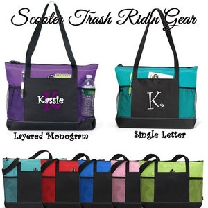May include: Two tote bags with different embroidery options. The first bag has a layered monogram with the name "Kassie" in purple. The second bag has a single letter "K" in white. Both bags have a black bottom section with a mesh pocket on each side. The bags are available in six different colors: teal, red, blue, pink, green, and black.