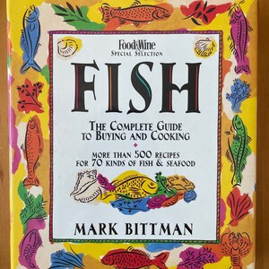 May include: A yellow book cover with a colorful illustration of fish and seafood. The title is "FISH: The Complete Guide to Buying and Cooking" with the subtitle "More than 500 recipes for 70 kinds of fish & seafood". The author is Mark Bittman.