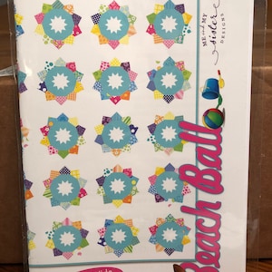 May include: A quilting pattern for a double wide Dresden block with a beach ball theme. The pattern includes 18 individual blocks with a variety of colorful fabrics. The pattern is titled "Beach Ball" and is by "Me and My Sister Designs".