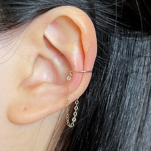 96) 14k goud gevuld, geen piercing, één band met kettingoormanchet. Eén of twee ketens.