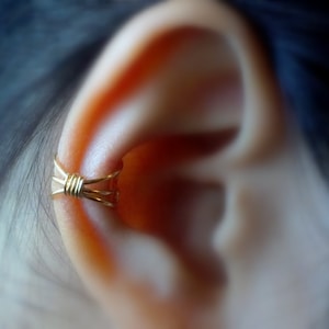 1) Geen piercing met drie banden en wikkeloormanchet **GOUDEN LICHAAM**