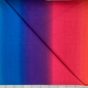 May include: A rainbow ombre fabric with a gradient of green, blue, purple, and red colors.