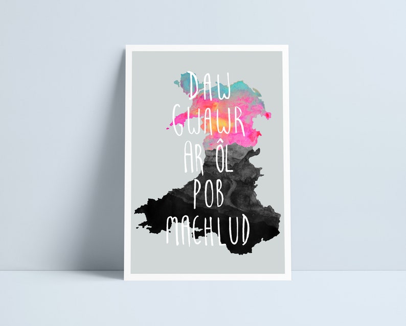 Puede incluir: Una impresi&oacute;n de acuarela del contorno de Gales con un cielo de puesta de sol colorido y la frase galesa "Daw Glawr Ar &Ocirc;l Pob Machlud" en texto blanco.