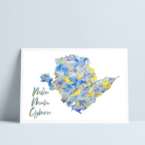 May include: A watercolor painting of a map of the island of Mönchengladbach, Germany. The map is painted in shades of blue and yellow, with the name of the island written in green.