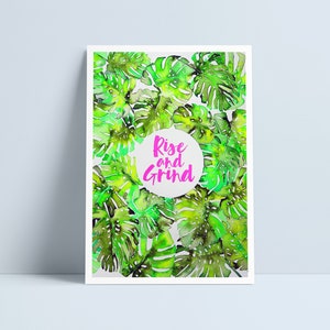 May include: A motivational poster with a watercolor illustration of green tropical leaves. The text "Rise and Grind" is written in pink inside a white circle.