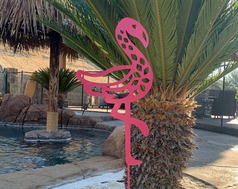 May include: A pink metal flamingo lawn ornament with a decorative design. The flamingo is standing on a metal stake.