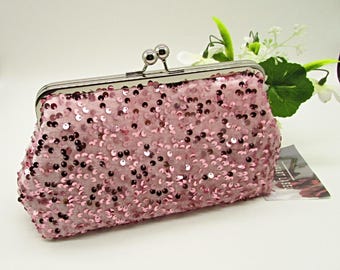 Op de afbeelding: Een roze pailletten clutch met een zilveren sluiting. De rechthoekige tas is bedekt met kleine, glanzende pailletten in verschillende roze tinten. De sluiting heeft twee kleine, ronde zilveren accenten. Een stijlvol accessoire.
