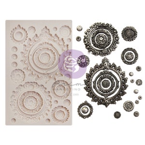 May include: A silicone mold with 14 different designs of ornate circles and small round shapes. The mold is white and the designs are raised. There are also 14 silver metal ornaments with the same designs as the mold.