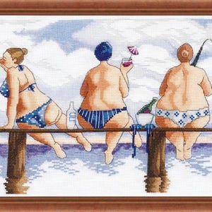 May include: Cross-stitch artwork depicting five figures in swimwear seated on a pier, enjoying wine and cake. The figures are facing away from the viewer, with a black cat on the right. The background shows water and sky.