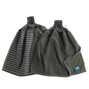 May include: Two hanging kitchen towels. One is dark gray with a white dotted pattern, and the other is solid dark gray with a chevron design. Both have a crocheted top with a button closure.