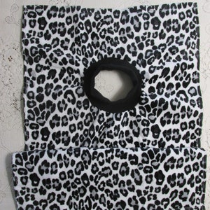 May include: A black and white leopard print fabric neck gaiter with a black elastic band.