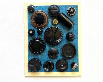 May include: A collection of black buttons of various shapes and sizes, including round, square, and oval, displayed on a blue background.