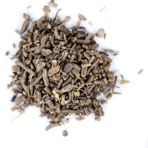 May include: A close-up of a pile of dried, brown, and gray roots. The roots are scattered on a white background.