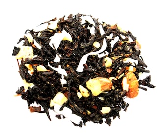 May include: A close-up of a blend of black tea leaves, shredded coconut, and almonds. The tea is a dark brown color and the almonds are light brown.