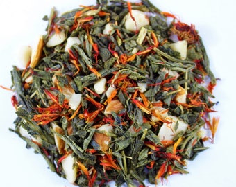 May include: A blend of green tea, almonds, and saffron. The tea is a mix of green leaves, orange-red saffron threads, and white almond pieces.