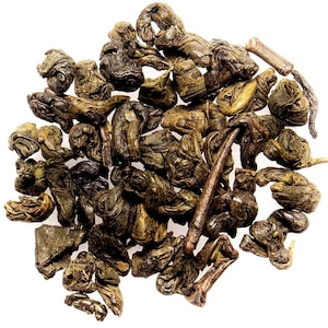 May include: A close-up of loose leaf green tea, the leaves are rolled into small balls and are a dark green color.