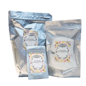 May include: Three silver resealable bags with labels that say "The Nelson's Bay Fill Your Own Fold Over Tea Bags". The bags are different sizes and are stacked on top of each other.